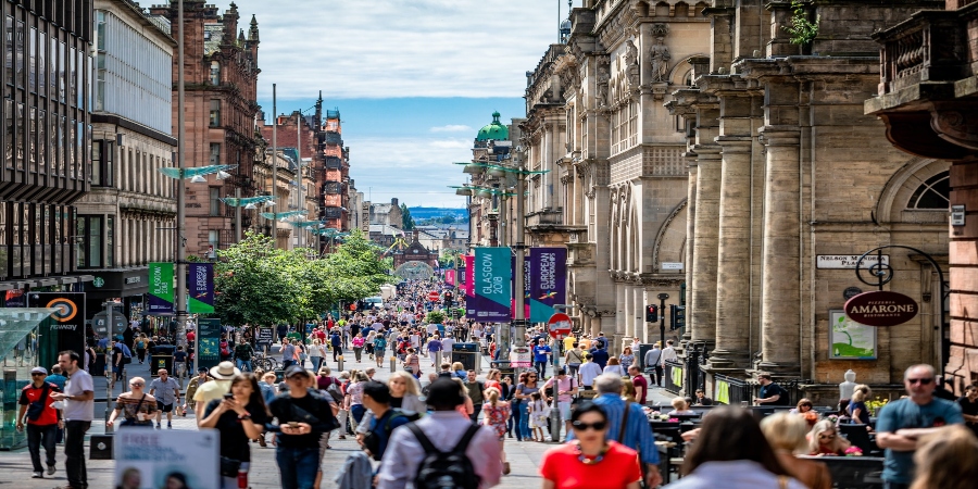 Glasgow's bustling street: Tourists exploring the vibrant cityscape filled with historic charm and lively atmosphere.