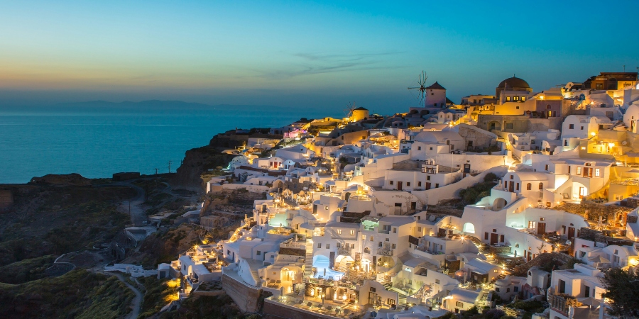 Night view of Santorini's iconic whitewashed buildings against the blue sea - a must-visit in Europe in summer
