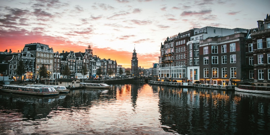 Amsterdam Canal with charming backdrop of houses: A picturesque scene capturing the timeless beauty of the iconic Dutch cityscape.
